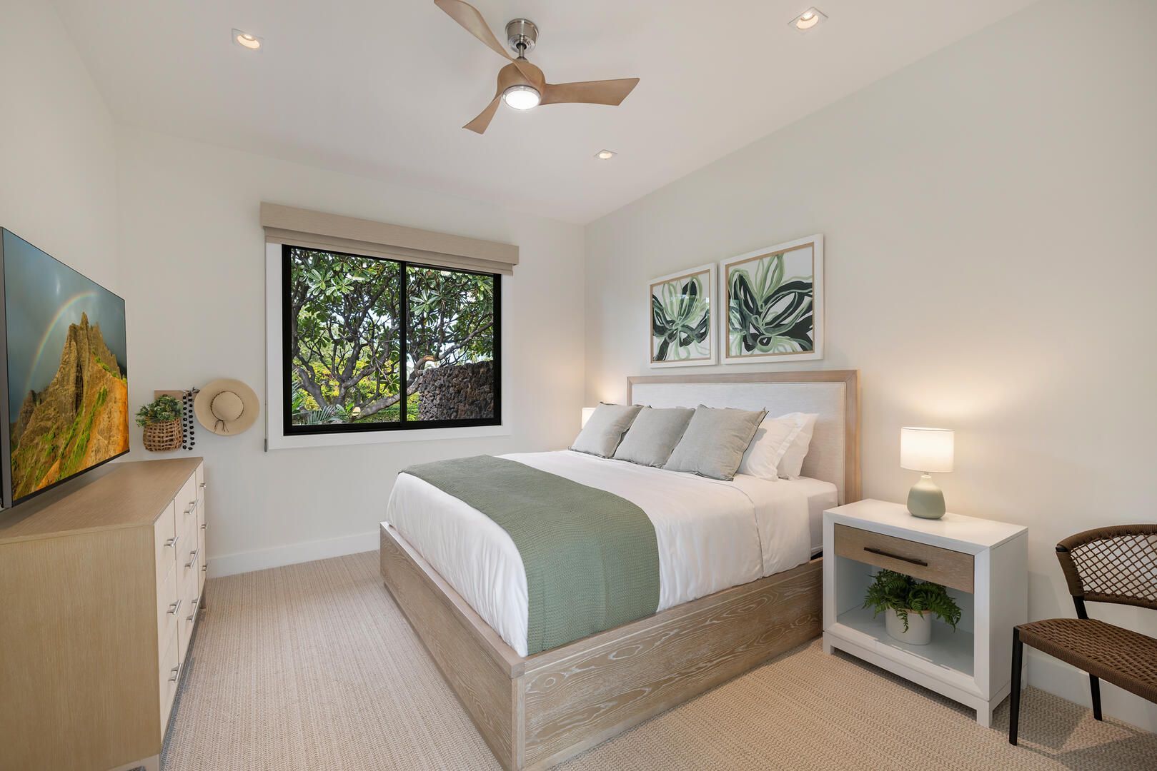 A bedroom with a bed , dresser , nightstand and television.
