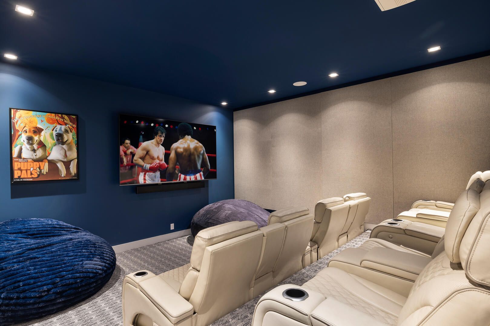 A home theater with a large flat screen tv on the wall.