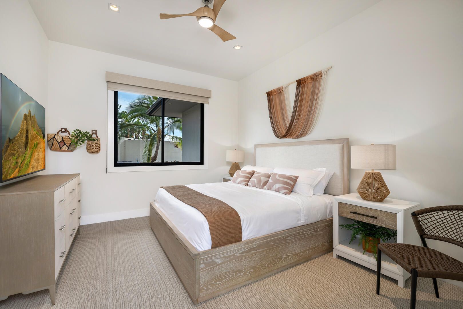 A bedroom with a bed , dresser , nightstand and television.