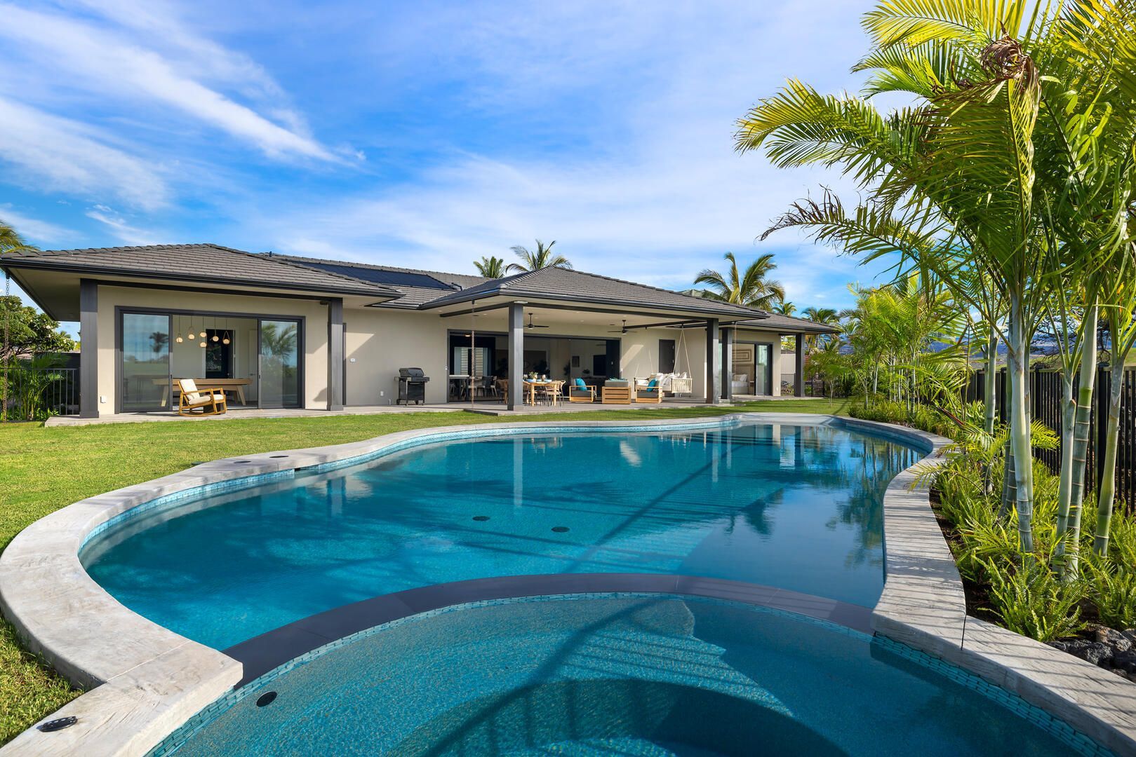 A large house with a large swimming pool in front of it
