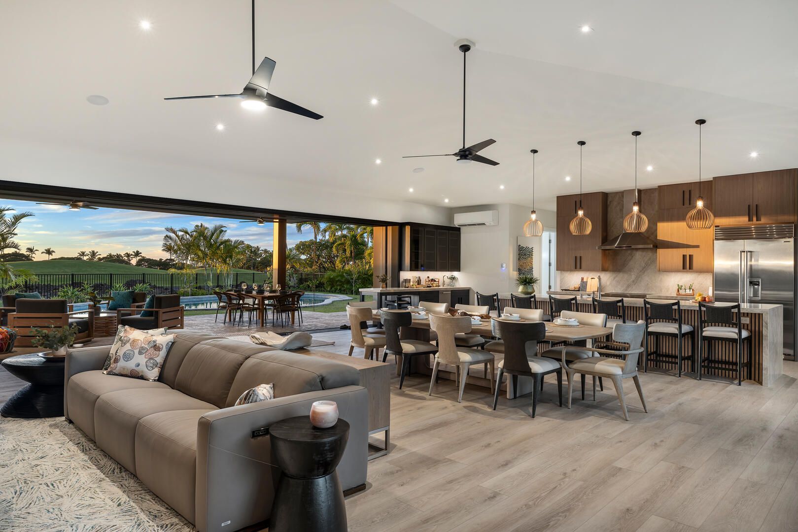 A living room with a couch , table , chairs and a ceiling fan.