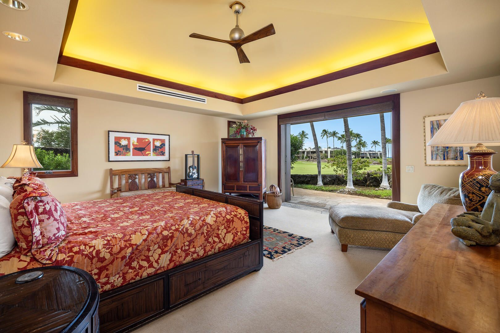Bedroom with a four-poster bed, large window, and a ceiling fan, featuring a neutral color scheme and warm lighting.