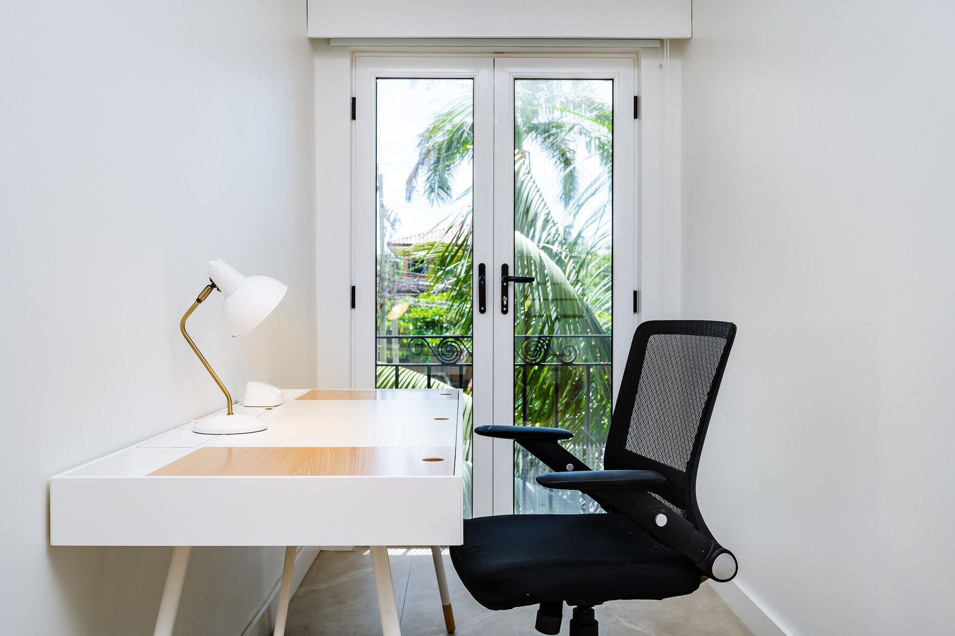 There is a desk and chair in the room with a window.