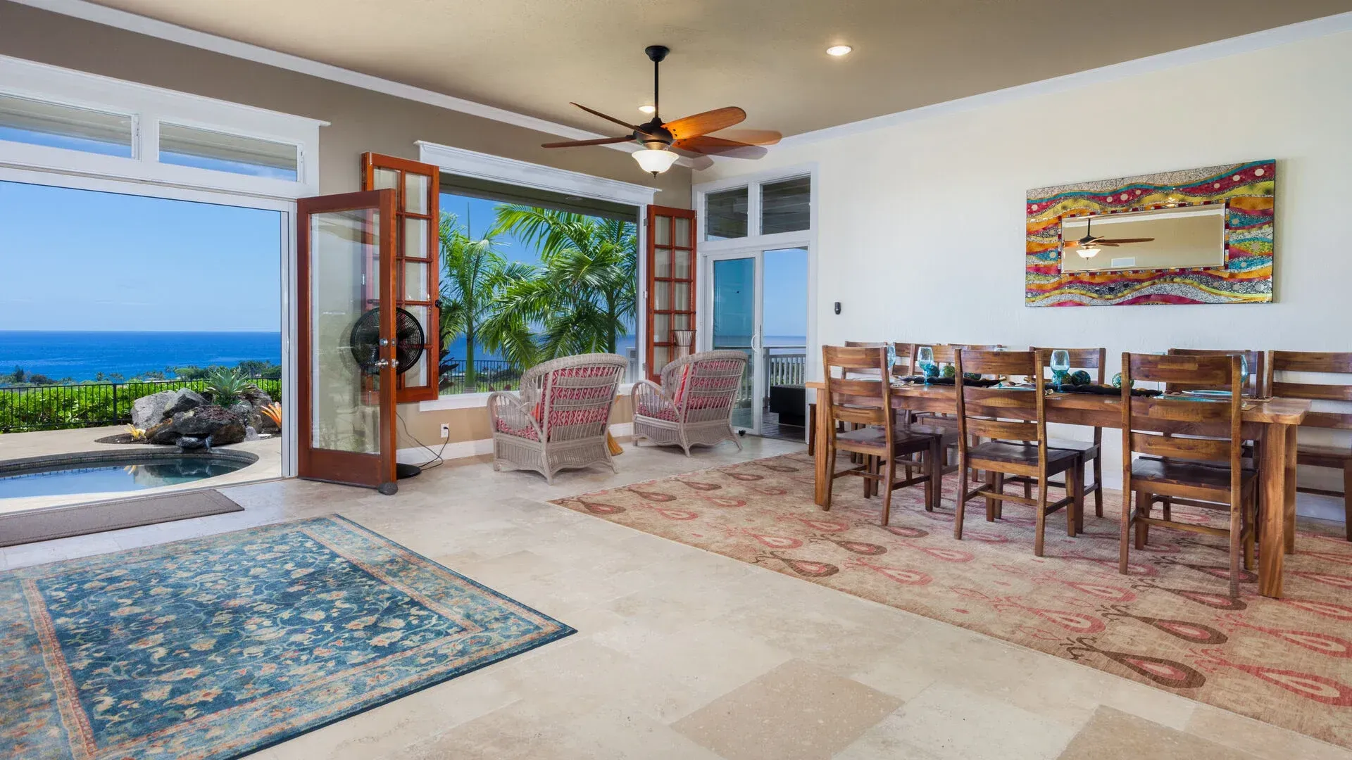 A living room with a table and chairs and a ceiling fan.