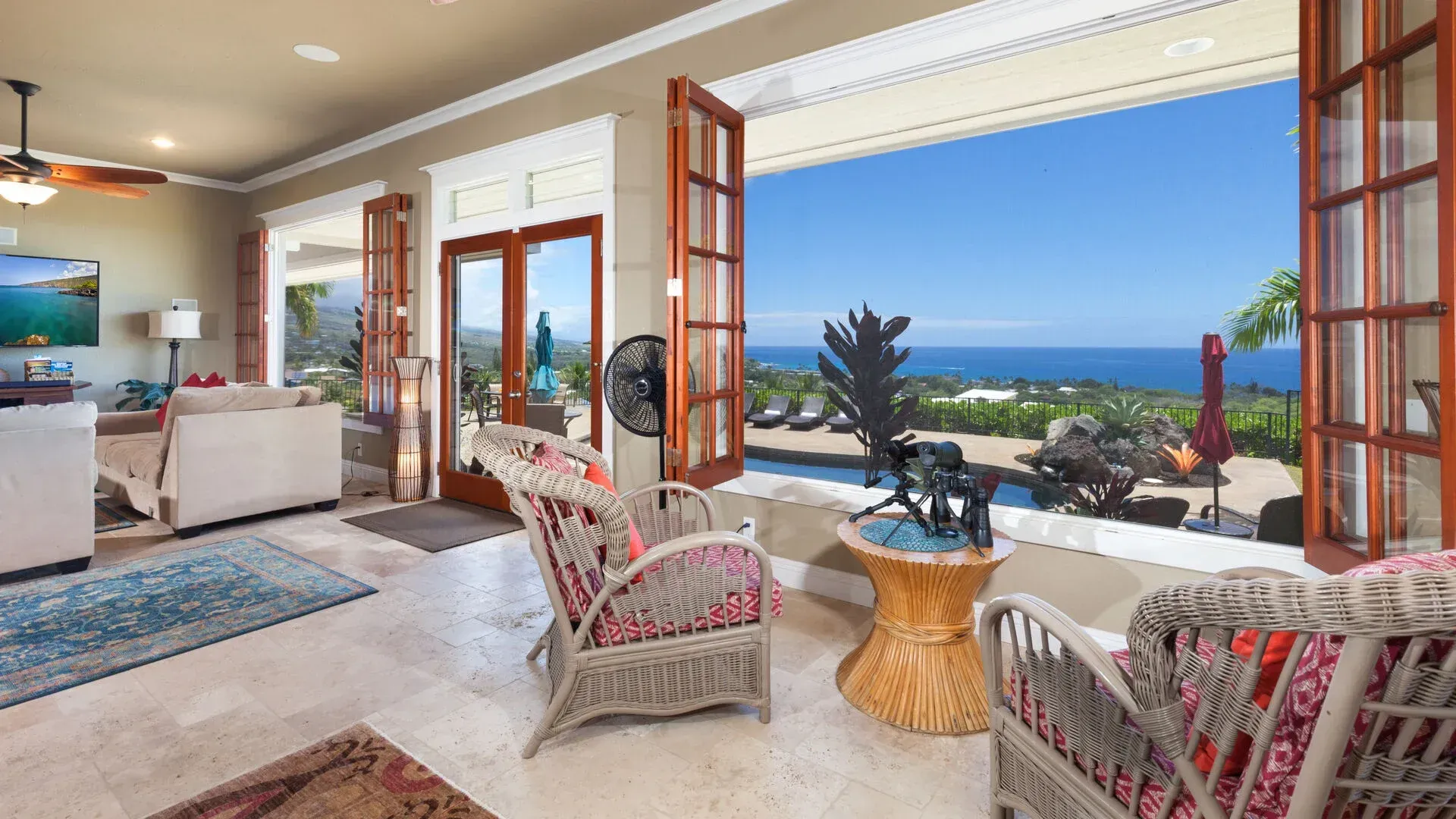 A living room with wicker furniture and a view of the ocean