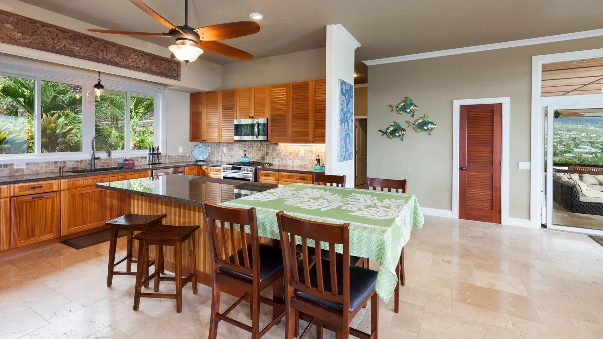 A kitchen with a table and chairs and a ceiling fan.