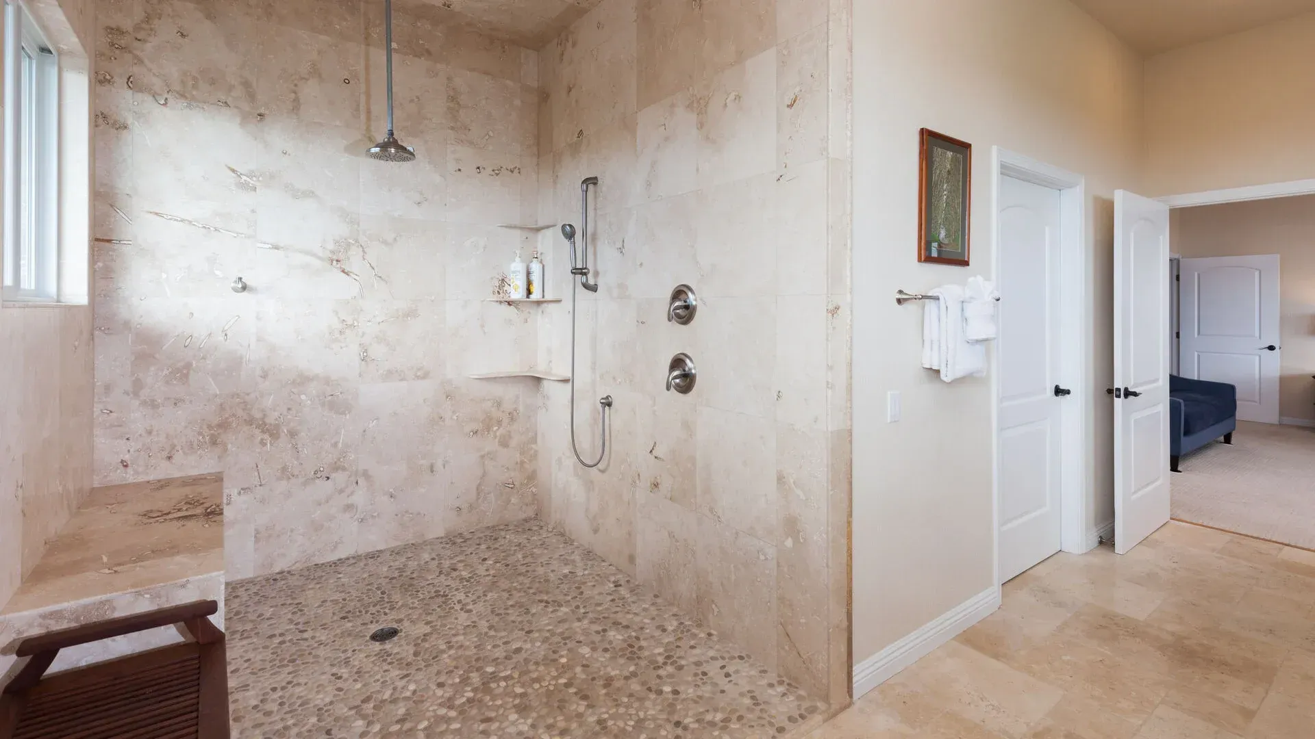 A bathroom with a walk in shower and a window.