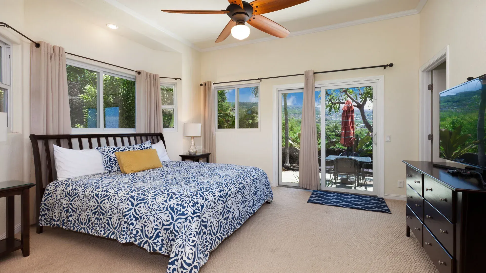 A bedroom with a large bed and a ceiling fan
