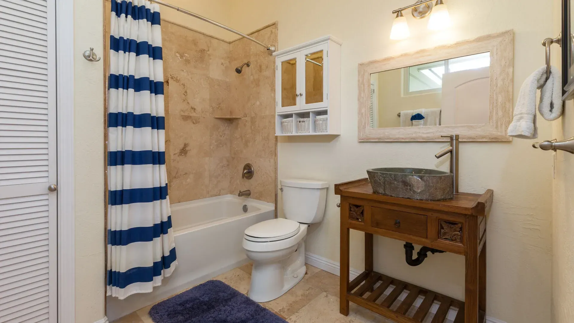 A bathroom with a toilet , sink , bathtub and shower curtain.