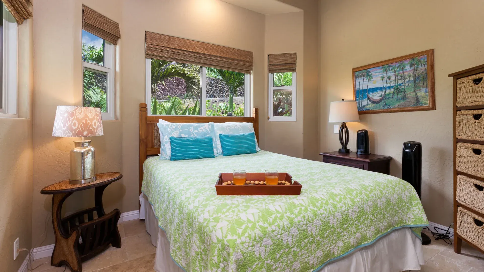 A bedroom with a bed , dresser , lamps and a picture on the wall.