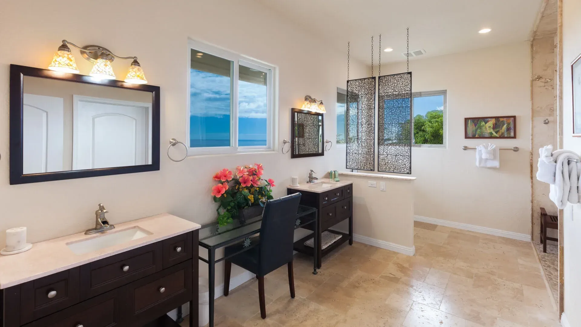 A bathroom with two sinks , two mirrors , a desk and a tub.