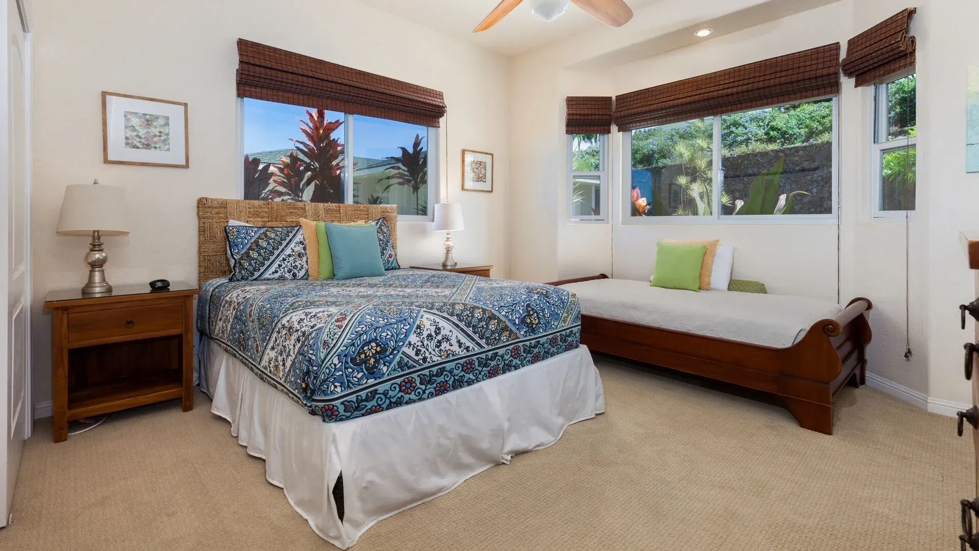 A bedroom with two beds and a ceiling fan