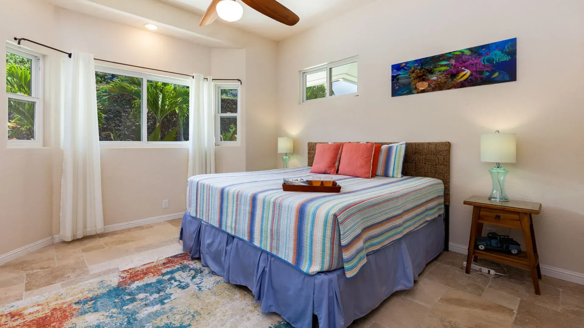 A bedroom with a king size bed and a ceiling fan.