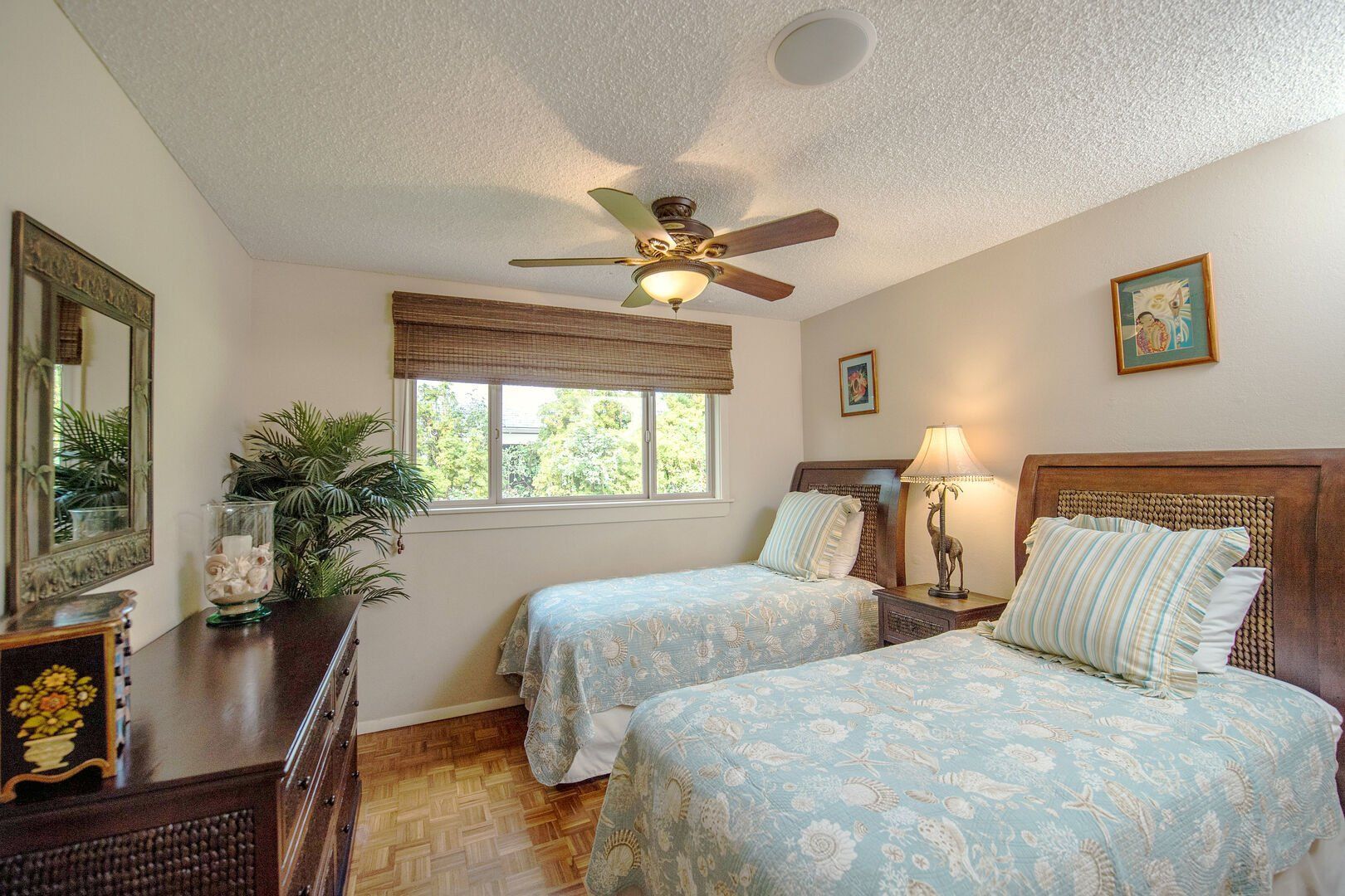 A bedroom with two twin beds and a ceiling fan.