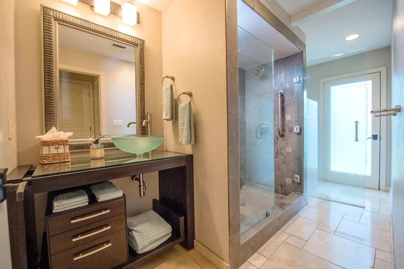 A bathroom with a sink , mirror , and walk in shower.