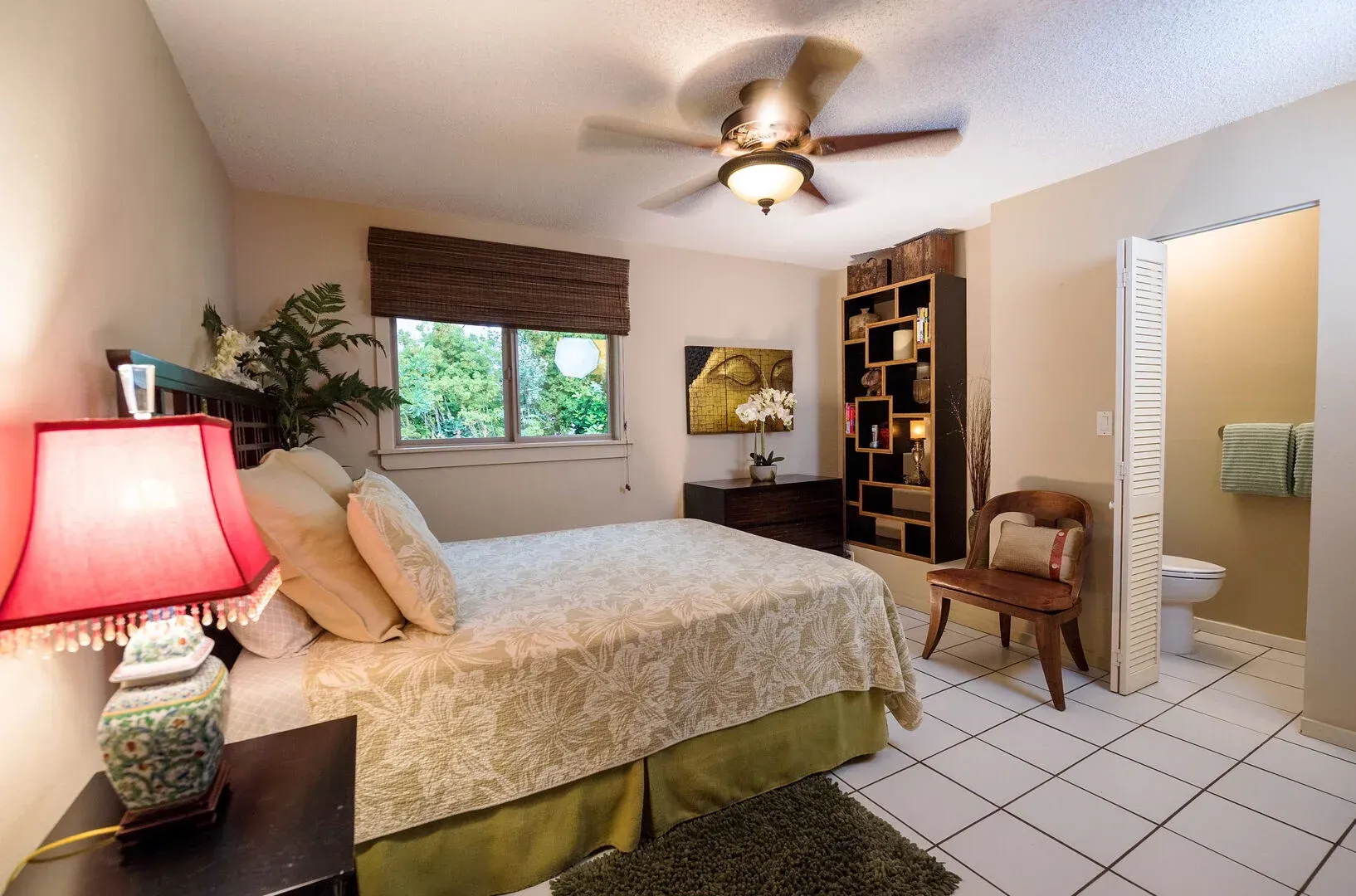 A bedroom with a large bed and a ceiling fan