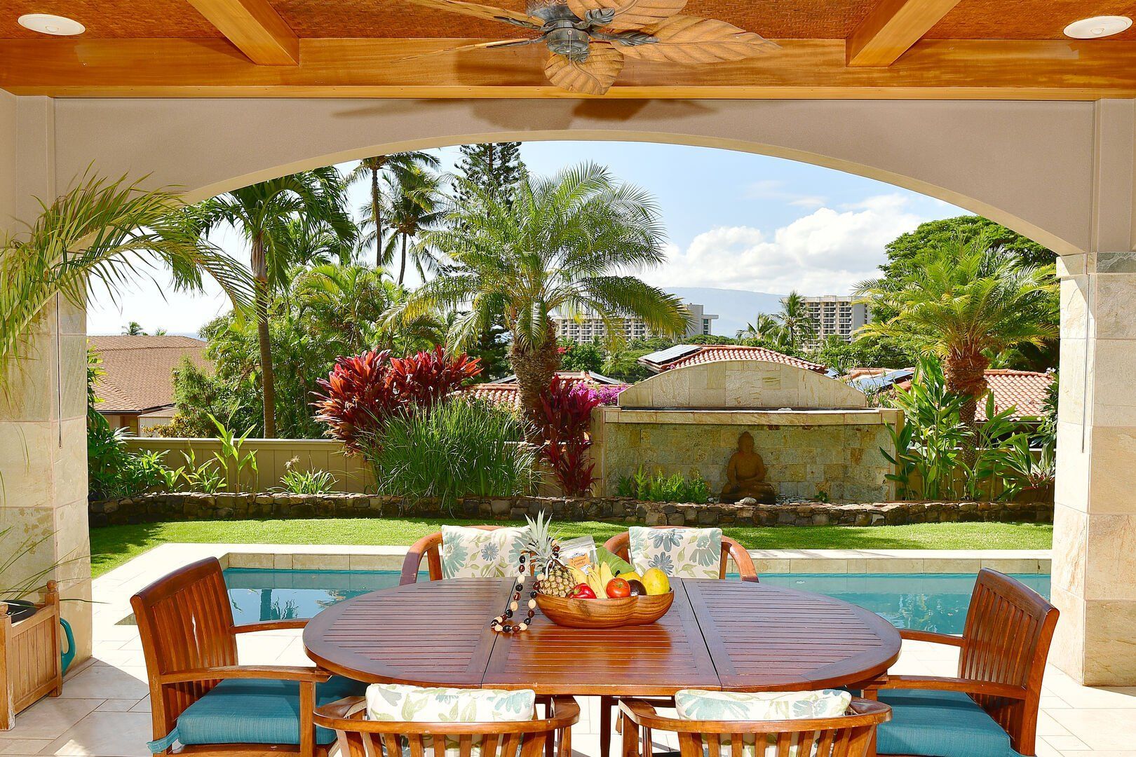 A patio with a table and chairs and a ceiling fan