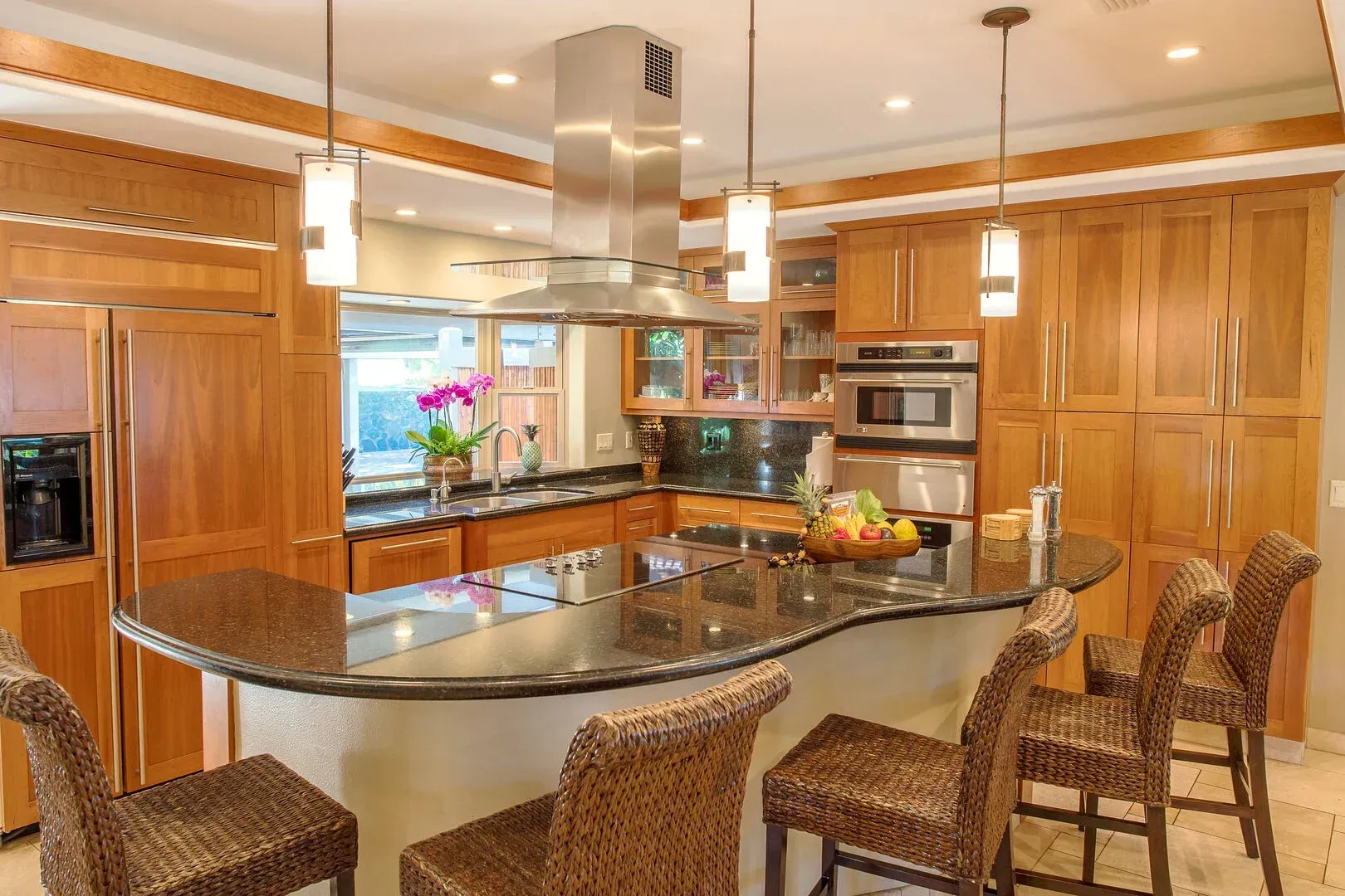A kitchen with a large island and wicker chairs