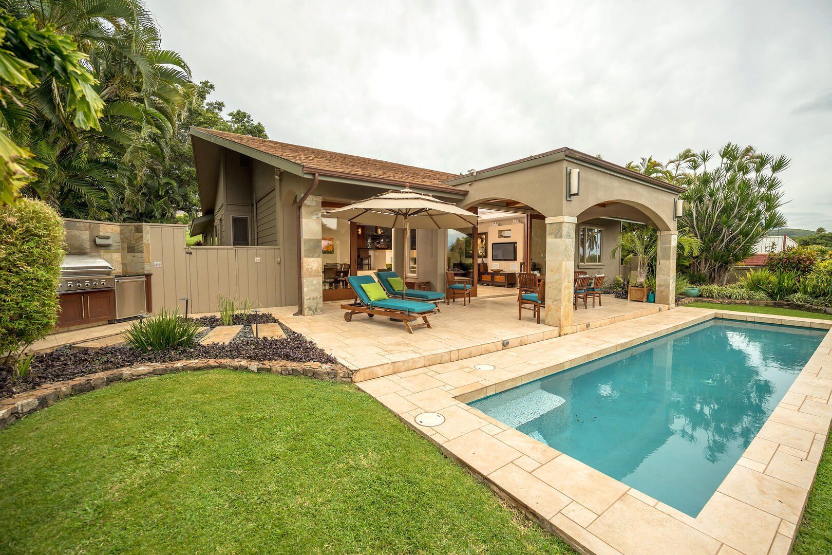 There is a large swimming pool in the backyard of a house.