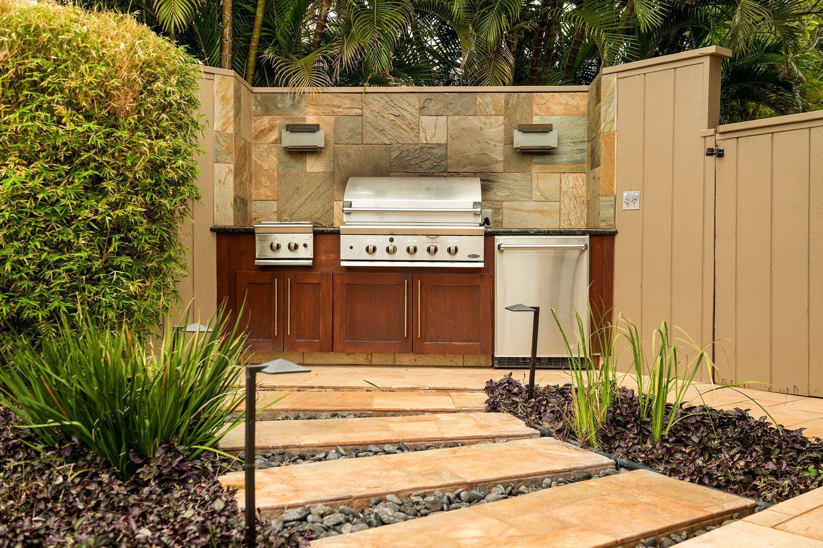 A patio with a grill and a walkway leading to it.