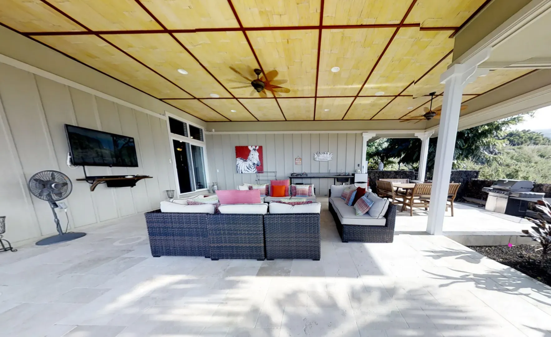 A living room with a couch and a television on the wall.