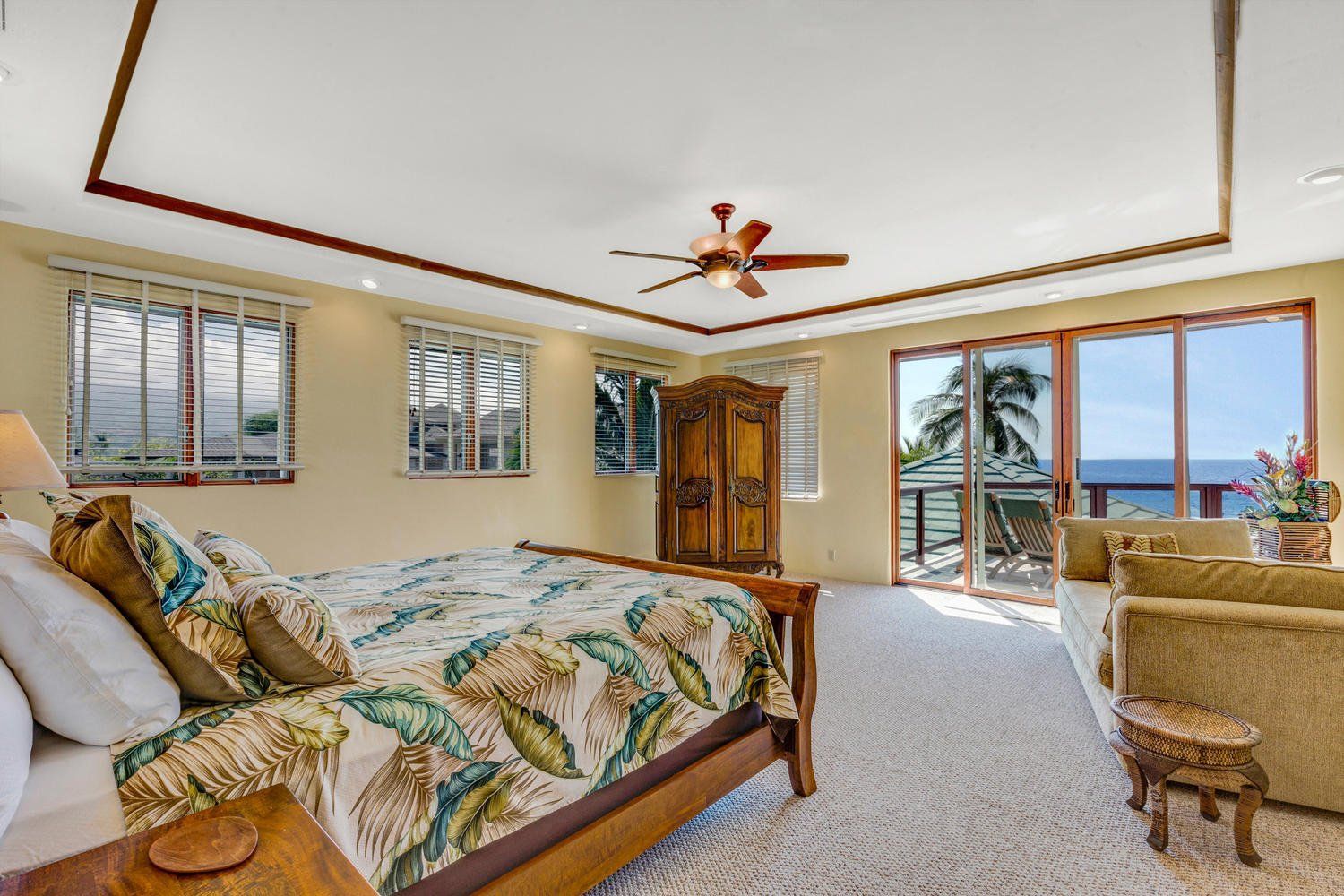 Bedroom with bed, sofa, and ocean view.