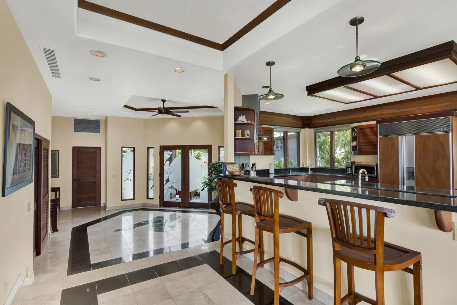 Interior view of a kitchen with a breakfast bar, wooden cabinets, and tiled floor.