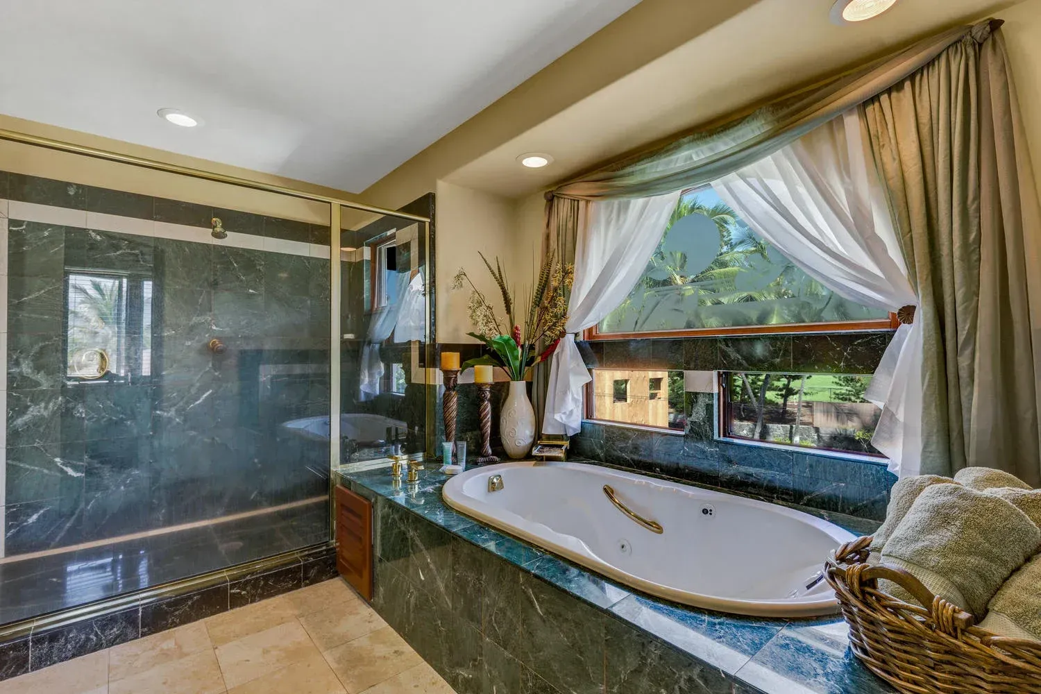 Bathroom with marble finishes, a jacuzzi tub by a window with curtains, and a glass shower.