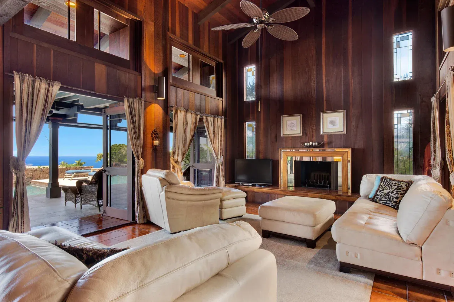 A living room with a fireplace and a ceiling fan