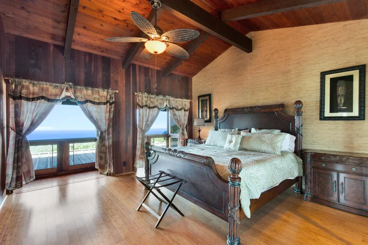 A bedroom with a large bed and a ceiling fan