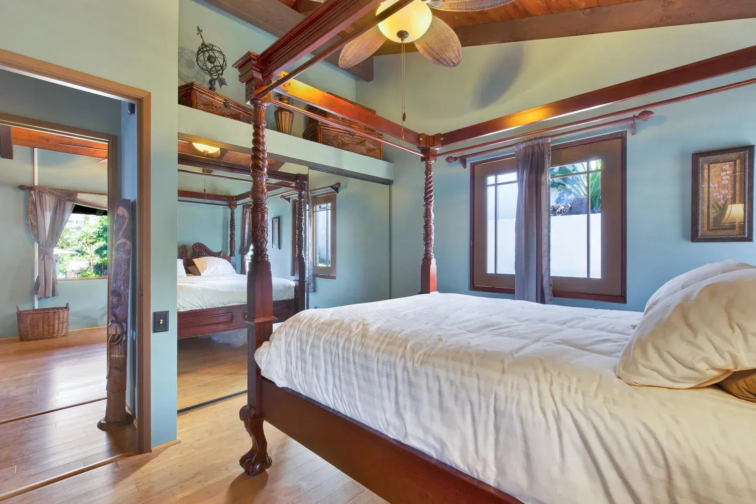 A bedroom with a four poster bed and a ceiling fan