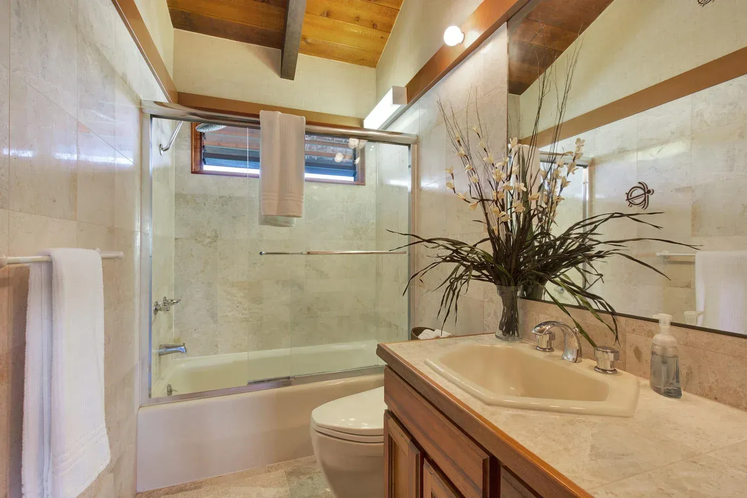 A bathroom with a sink , toilet , tub and mirror.