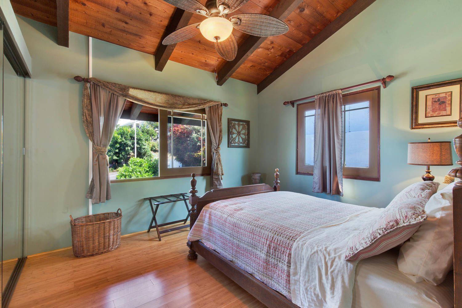 A bedroom with a large bed and a ceiling fan