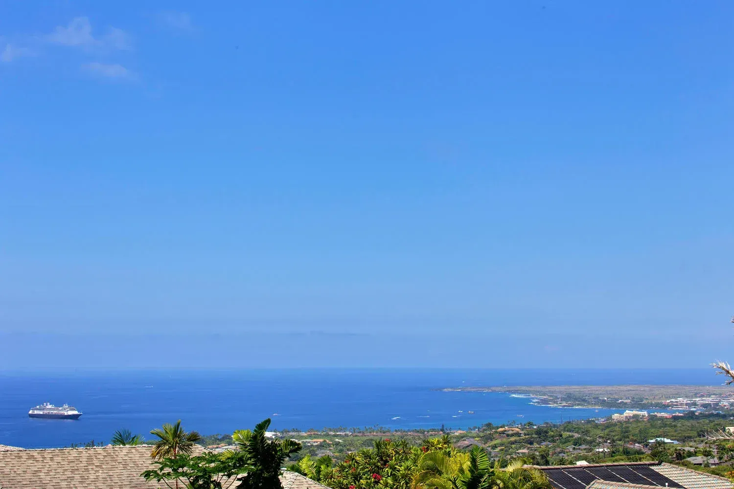 A view of the ocean from a rooftop with a boat in the distance.