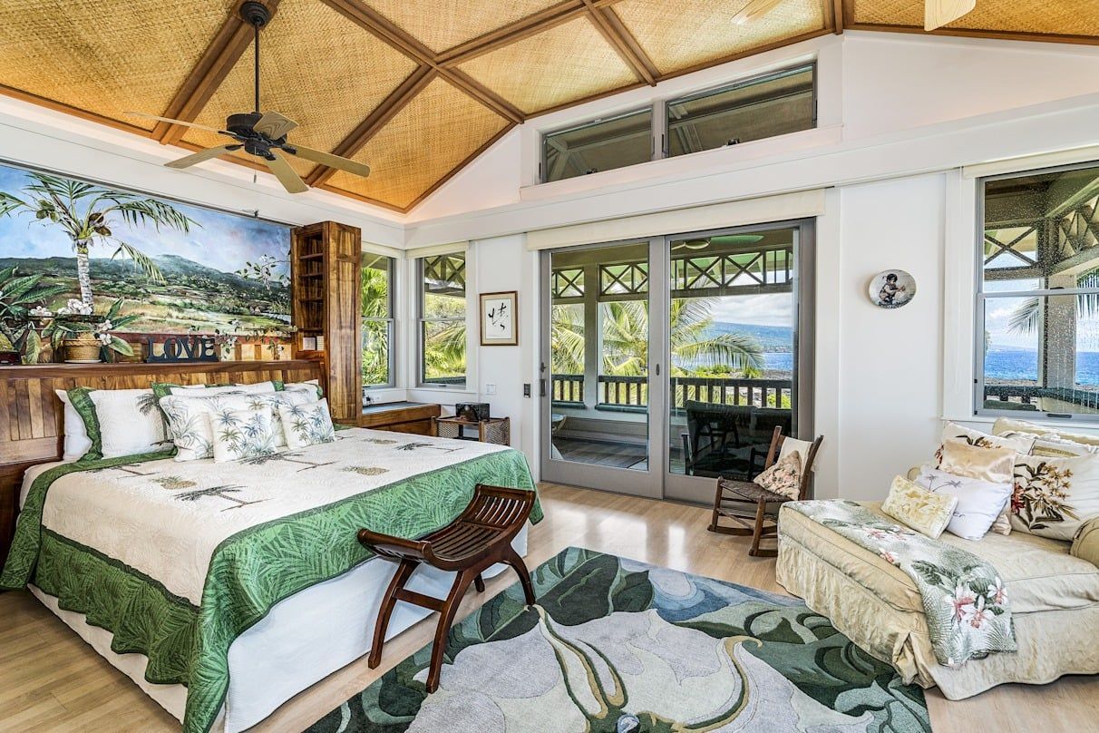 A bedroom with a king size bed , a couch , and a rug.