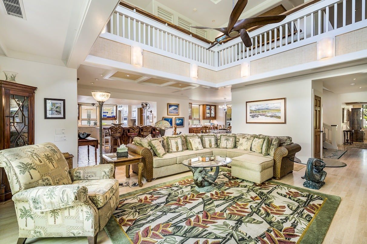 A living room filled with furniture and a ceiling fan.