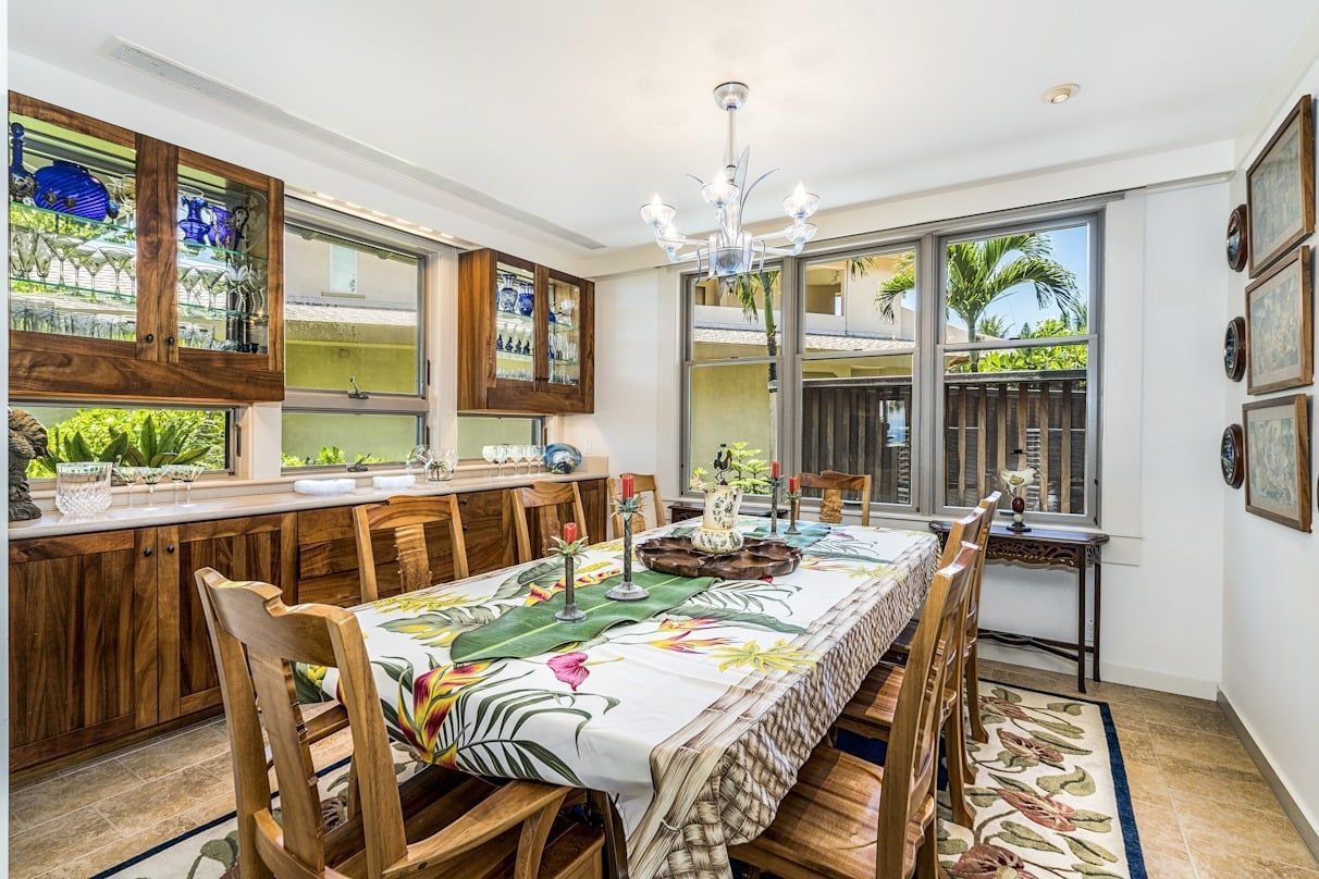 A dining room with a long table and chairs and a chandelier.