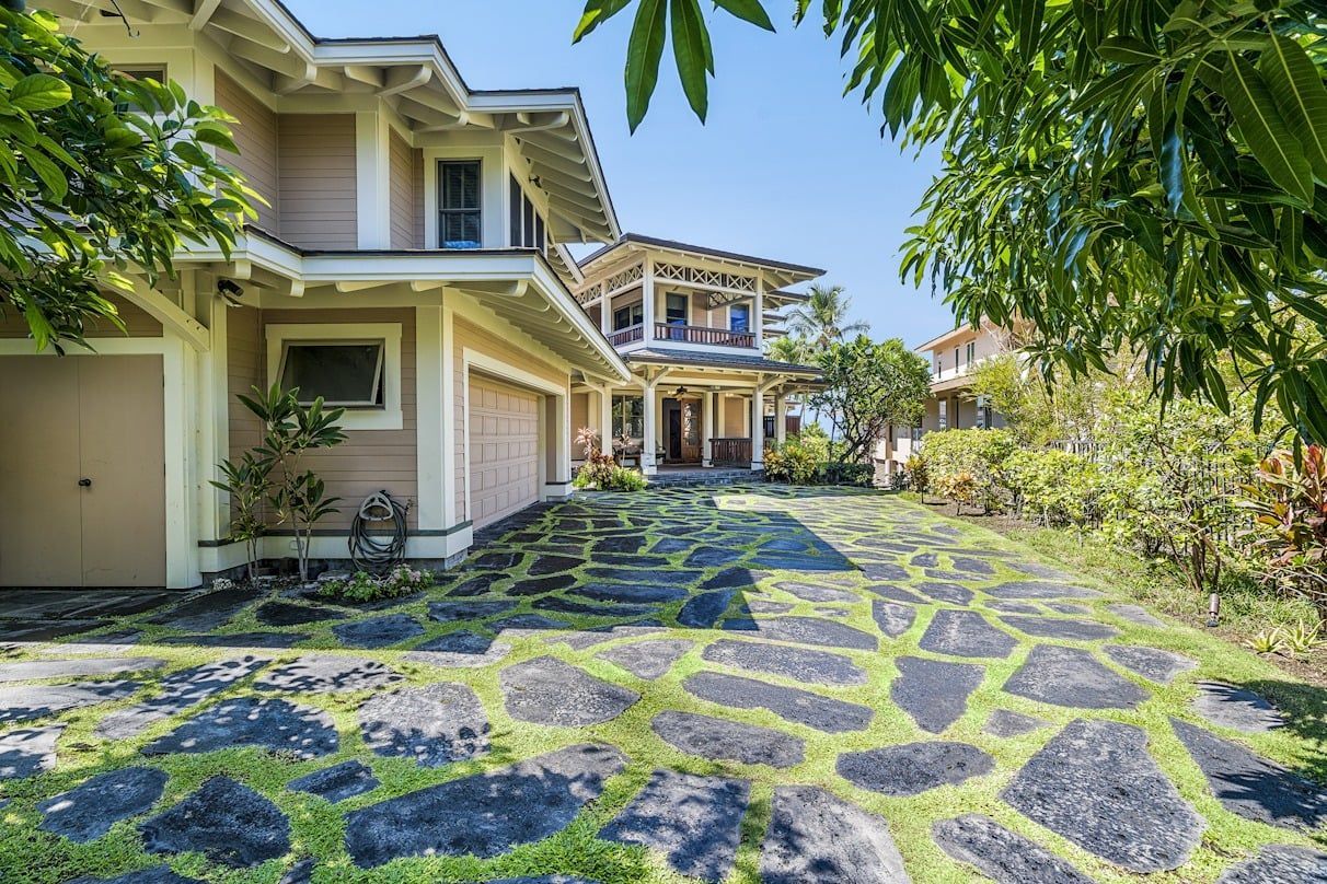 A large house with a stone driveway leading to it.