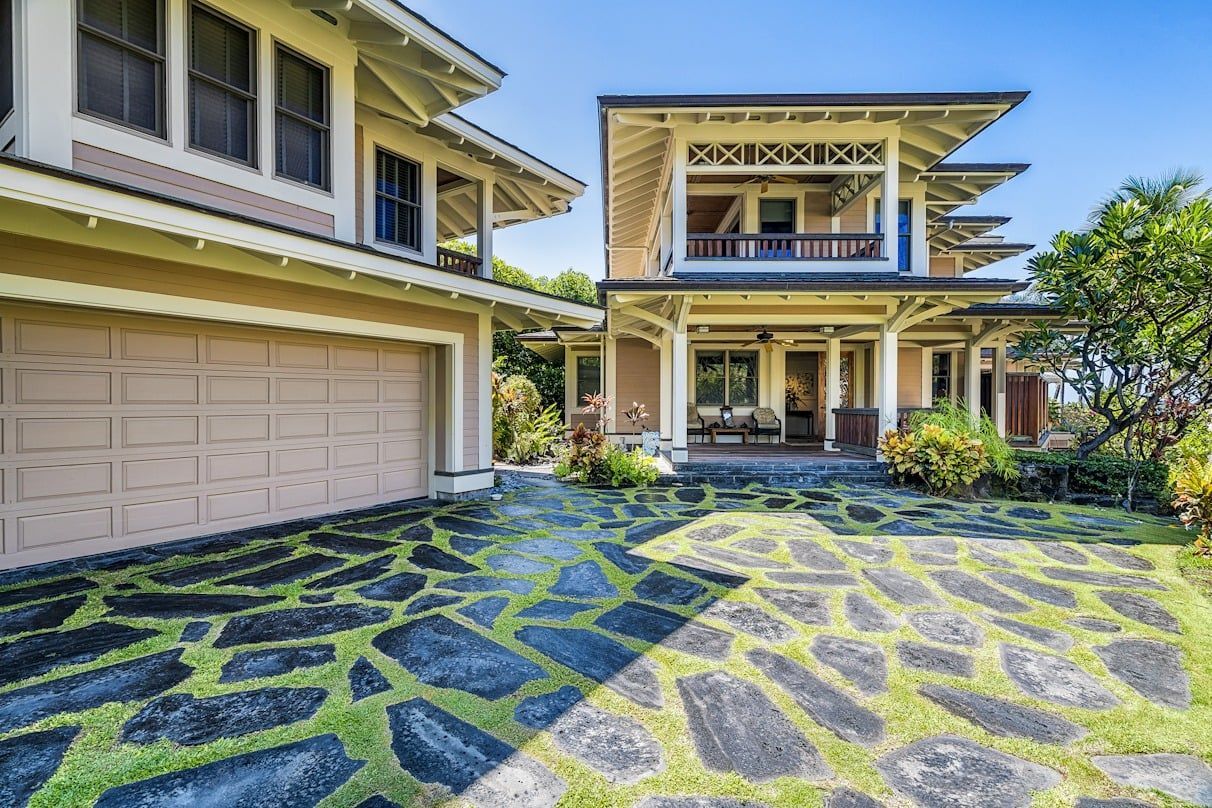 A large house with a stone driveway in front of it.
