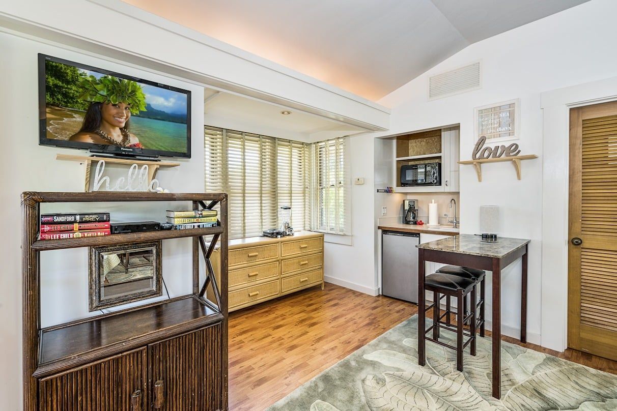 A living room with a table and a television on the wall.
