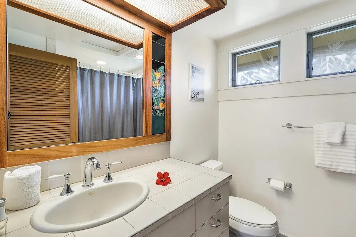 A bathroom with a sink , toilet and mirror.