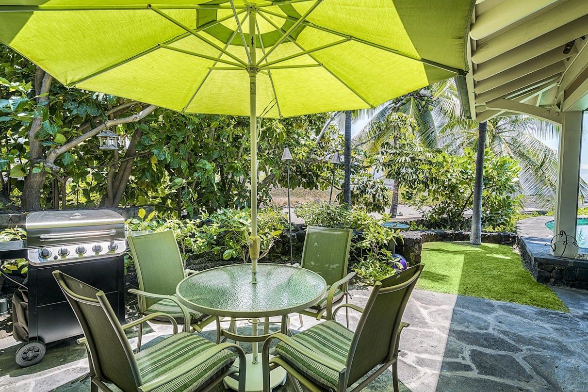 A patio with a table and chairs under an umbrella.