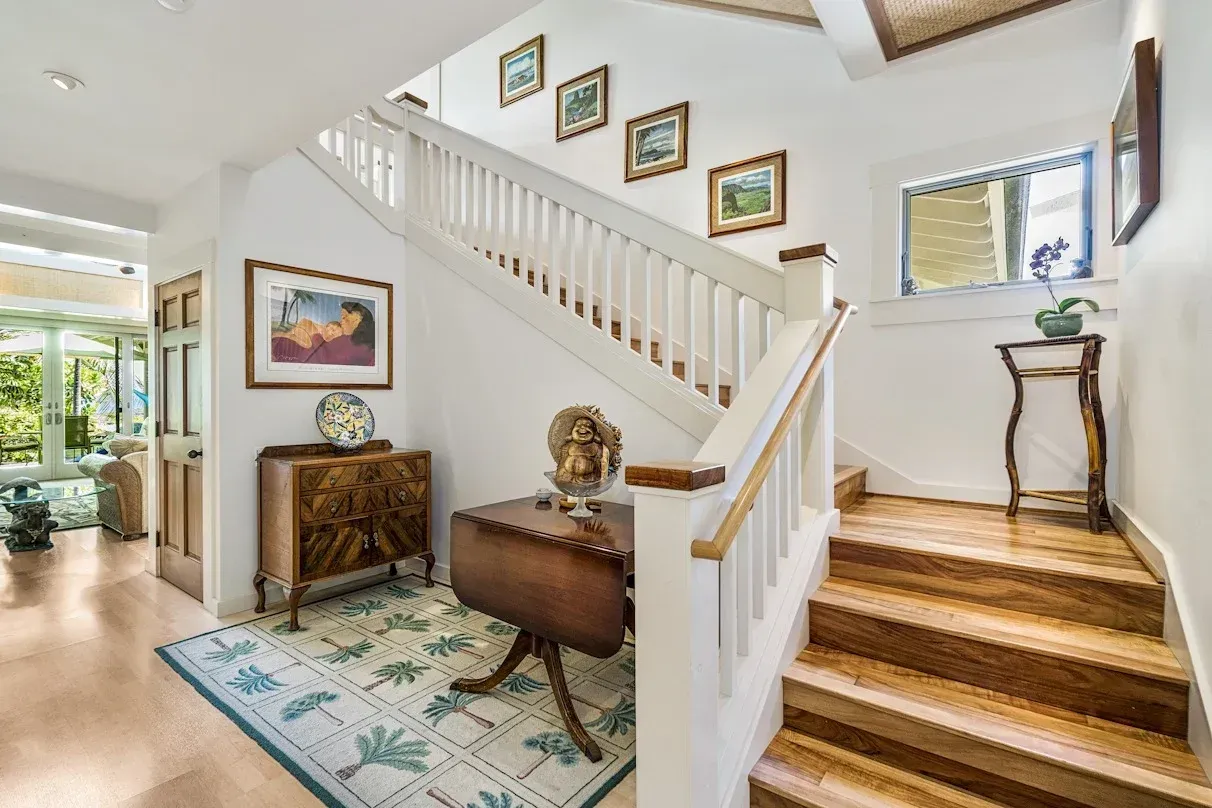 A hallway with stairs leading up to the second floor of a house.