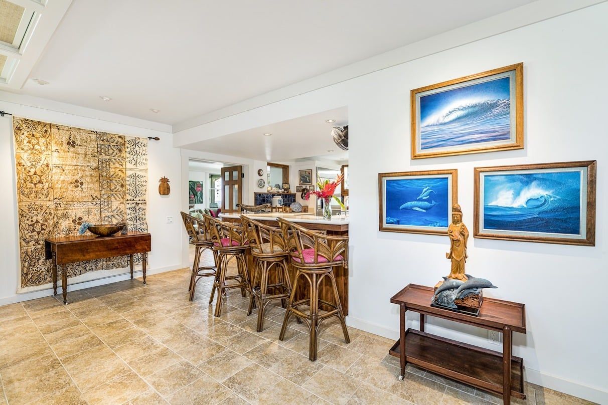 A living room with a bar and paintings on the wall.