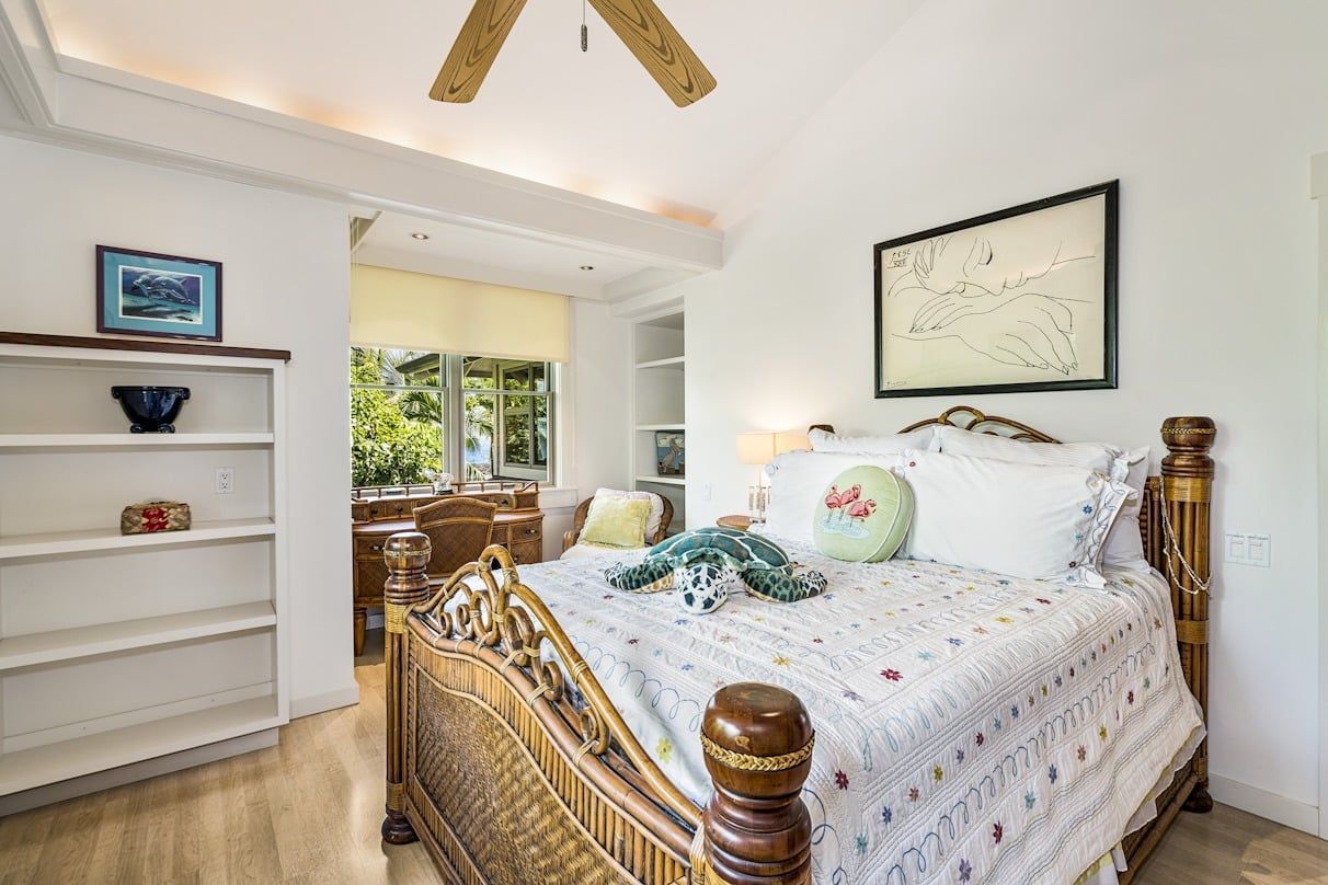 A bedroom with a king size bed and a ceiling fan.