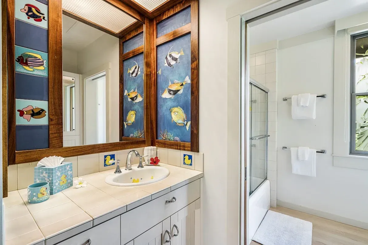 A bathroom with a sink , mirror , and shower.