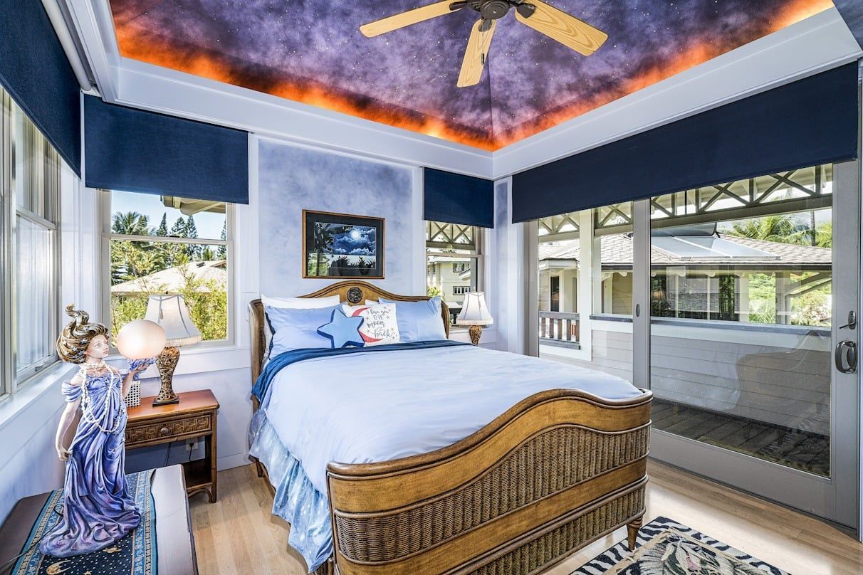 A bedroom with a bed and a ceiling fan