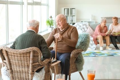 Elderly men playing chess in shared lounge room