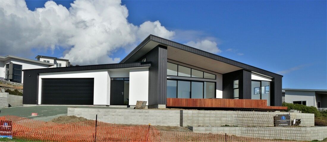 A large house is being built on top of a hill.