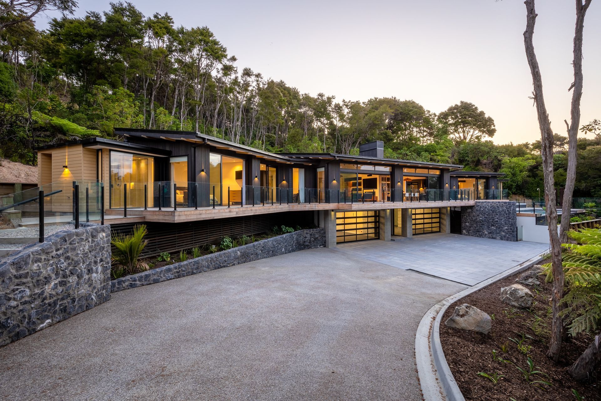 A large house is sitting on top of a hill surrounded by trees.
